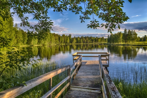 Pier mit Holzbänken am See in Lappland