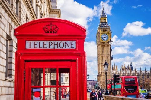 traditionelle rote britische Telefonzelle mit Big Ben und Doppeldeckerbus im Hintergrund in London